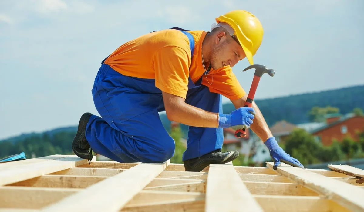 Construction-couvreur-ouvrier-charpentier-clouer-planche-de-bois-avec-un-marteau-sur-les-travaux-dinstallation-sur-le-toit